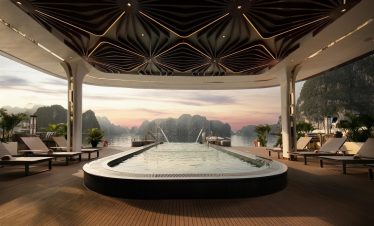 Scenic sunset view from cruise balcony in Halong Bay, showcasing tranquil waters and limestone islan.