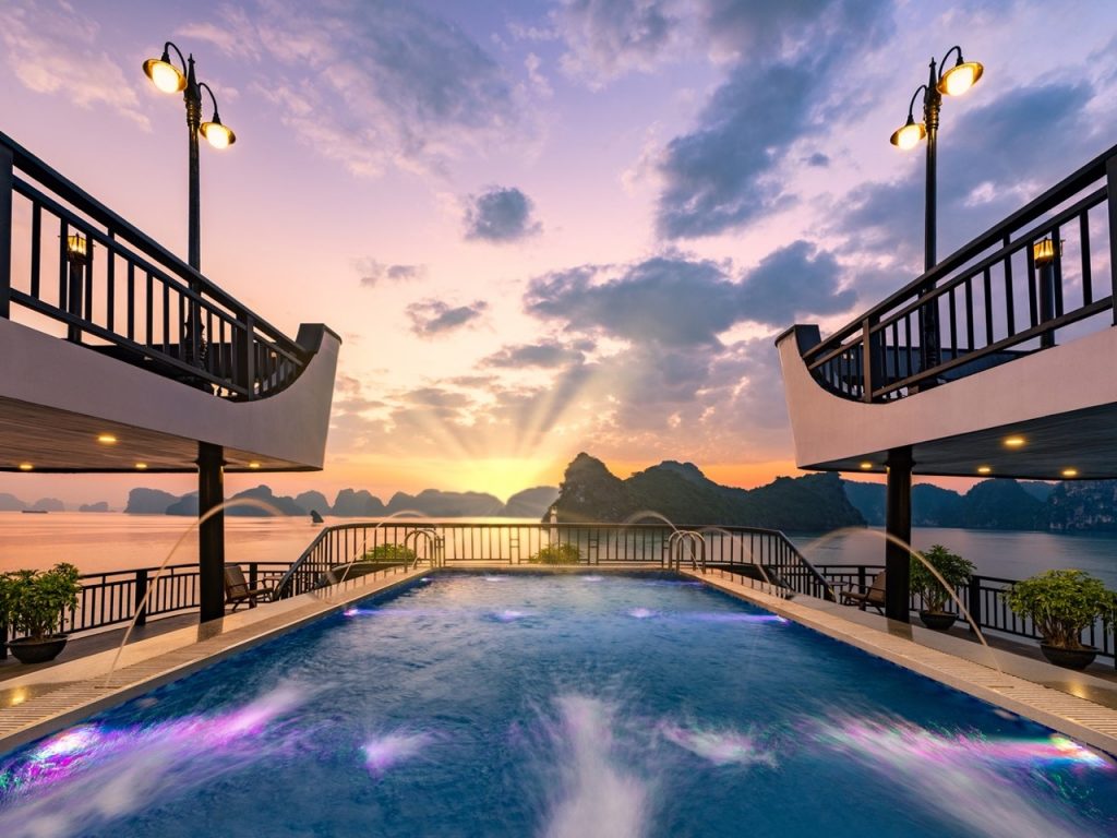 Sunset view from cruise balcony in Halong Bay with scenic limestone islands - ViettrendTour.