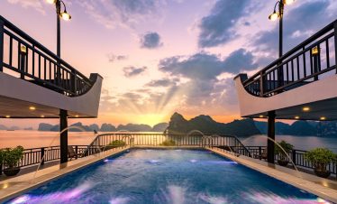 Sunset view from cruise balcony in Halong Bay with scenic limestone islands - ViettrendTour.