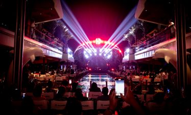 ViettrendTour event with stage lighting, people enjoying concert at night, tropical setting.