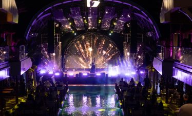 Colorful nightclub stage with vibrant lights and entertainment for tourist celebrations.