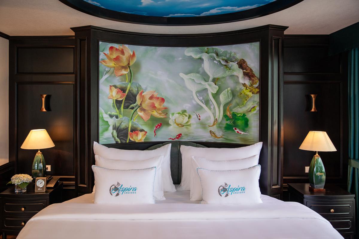 Bright hotel room with aquatic-themed artwork, plush bedding, and elegant dark wood furniture. Ideal for luxury travelers.