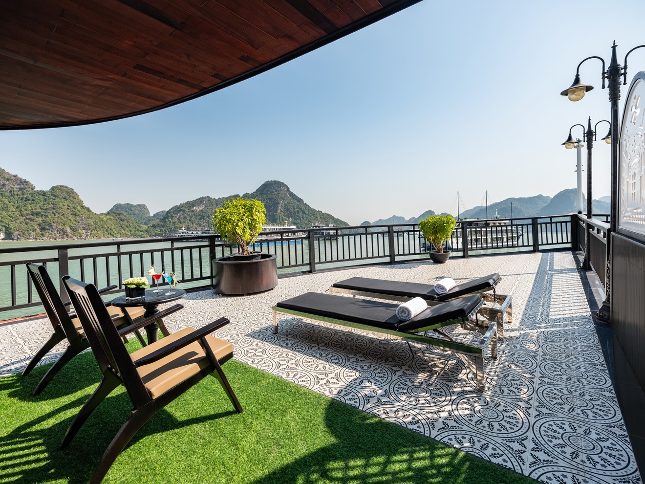 Beautiful Halong Bay cruise balcony showcasing panoramic mountain views and luxurious relaxation.