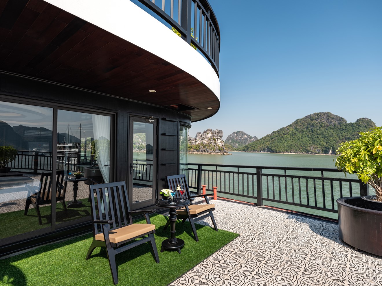 Stunning balcony scene on Halong Bay cruise with panoramic water views and lush islands.