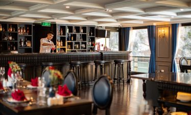 A sophisticated lounge area on a Halong Bay cruise with stylish furnishings and scenic views.