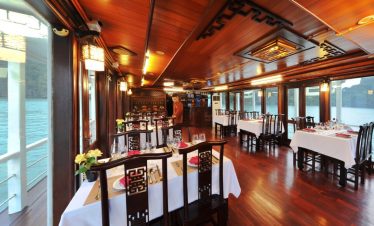 Luxurious cruise balcony overlooking Halong Bay with calm waters and scenic karst formations - Viett.