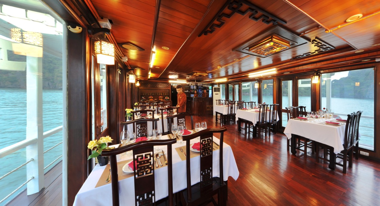 Luxurious cruise balcony overlooking Halong Bay with calm waters and scenic karst formations - Viett.