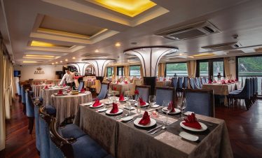 Luxurious cruise dining room in Halong Bay with elegant table settings and panoramic views, perfect.