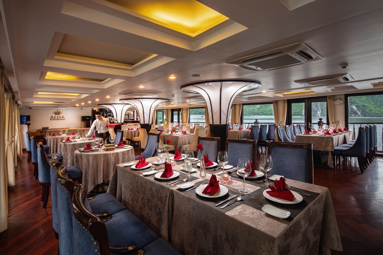 Luxurious cruise dining room in Halong Bay with elegant table settings and panoramic views, perfect.