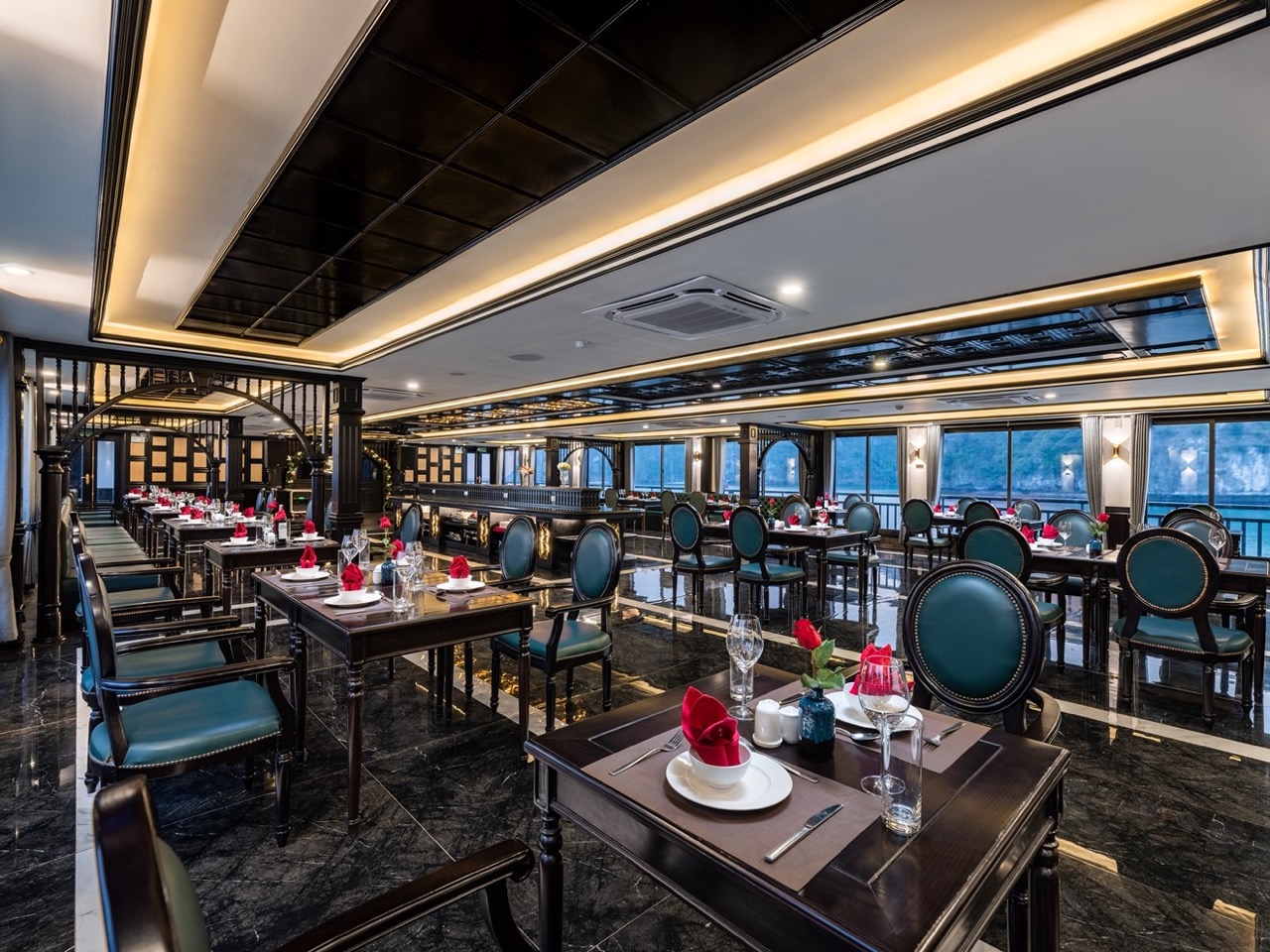 Luxurious cruise dining room with elegant decor and panoramic bay views in Halong Bay.