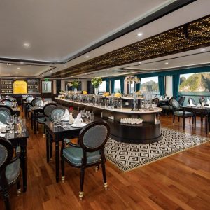 Elegant cruise ship dining room with ocean views and luxurious decor.