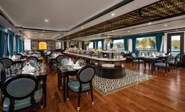 Elegant cruise ship dining room with ocean views and luxurious decor.