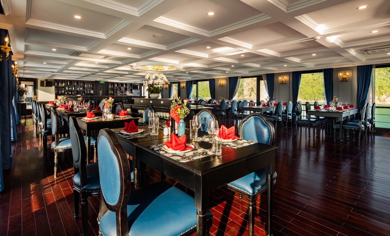Elegant cruise dining room with panoramic views of Halong Bay, perfect for a romantic dinner.