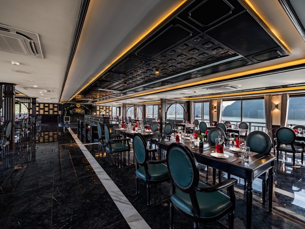Elegant cruise dining room with panoramic Halong Bay views and sophisticated decor.