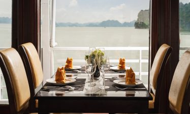 Scenic view of a luxurious dining table on a cruise balcony overlooking Halong Bay, perfect for a re.