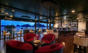 Luxurious cruise lounge overlooking Halong Bay with comfortable seating and scenic vistas.