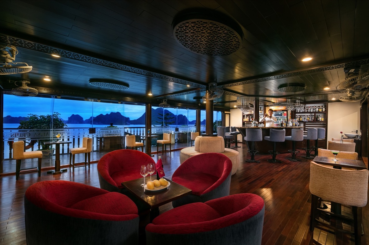 Luxurious cruise lounge overlooking Halong Bay with comfortable seating and scenic vistas.