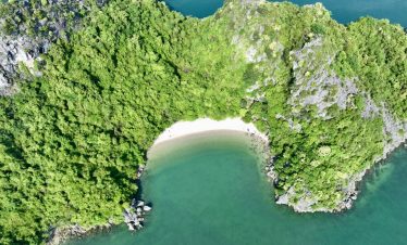 Aerial view of Bai Tu Long Bay Cruise 2 nights with lush green islands and turquoise waters, perfect for a scenic cruise.