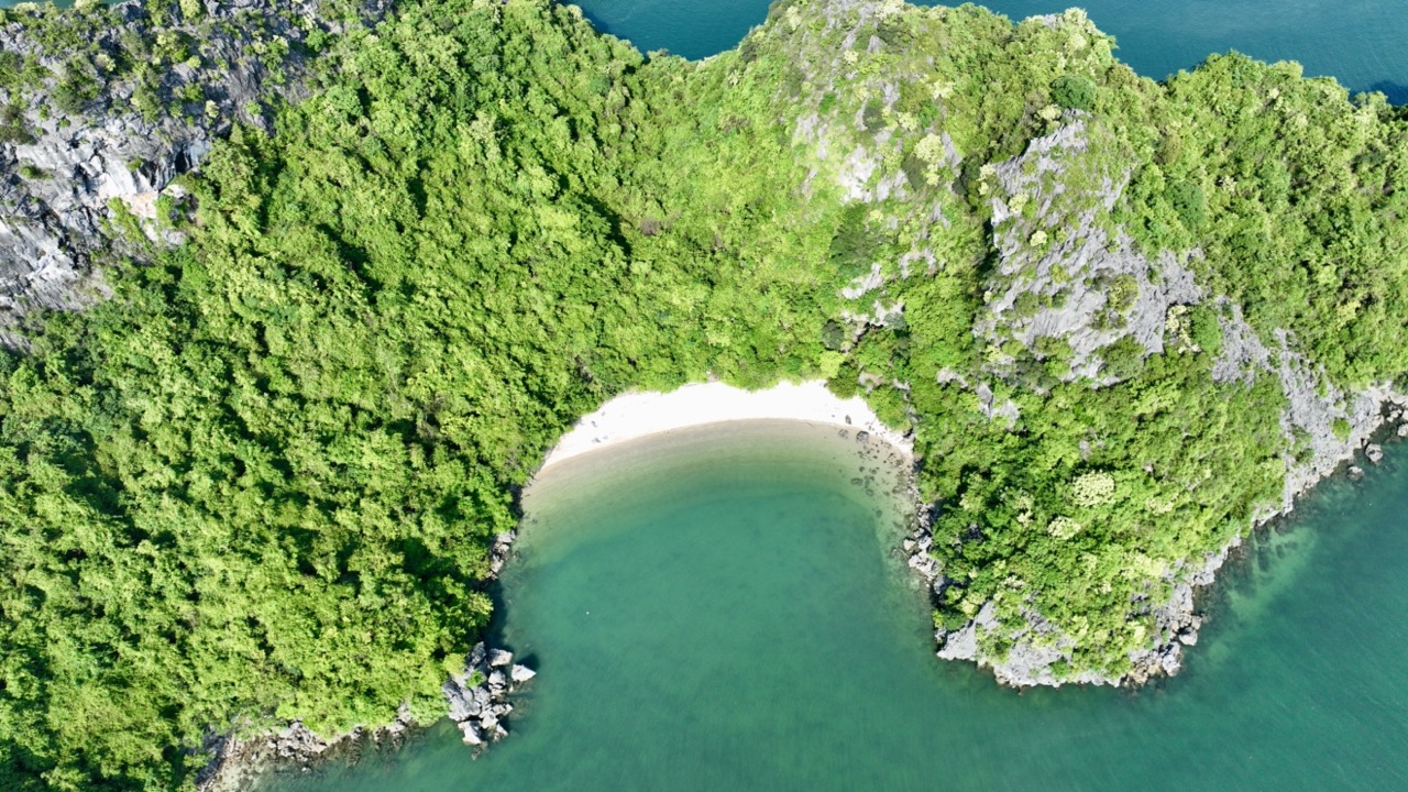 Aerial view of Bai Tu Long Bay Cruise 2 nights with lush green islands and turquoise waters, perfect for a scenic cruise.