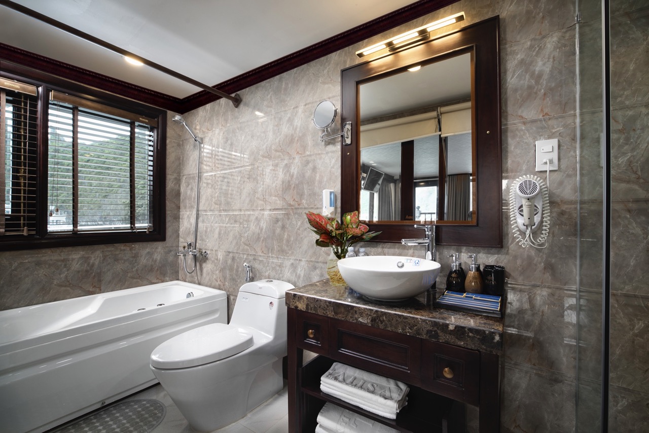 Elegant bathroom featuring a bathtub, toilet, and stylish vanity with mirror, perfect for relaxing a.