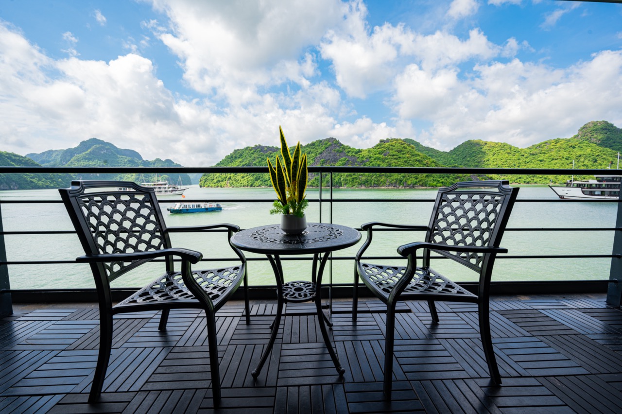 Halong Bay cruise balcony with scenic mountain views and tranquil waters.