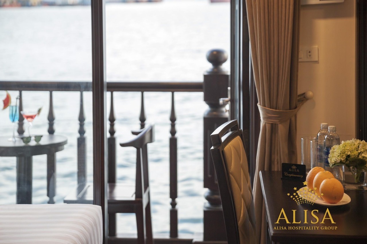 Scenic view of Halong Bay from a cruise balcony with tranquil waters and stunning limestone formatio.