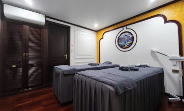 Interior of luxurious cruise cabin with twin beds and modern amenities.