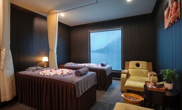 Beautiful cruise cabin with large window view of Halong Bay, featuring comfortable beds and relaxing.