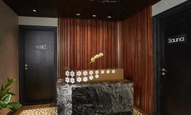 Elegant cruise lounge with wooden paneling and relaxing ambiance in Halong Bay.