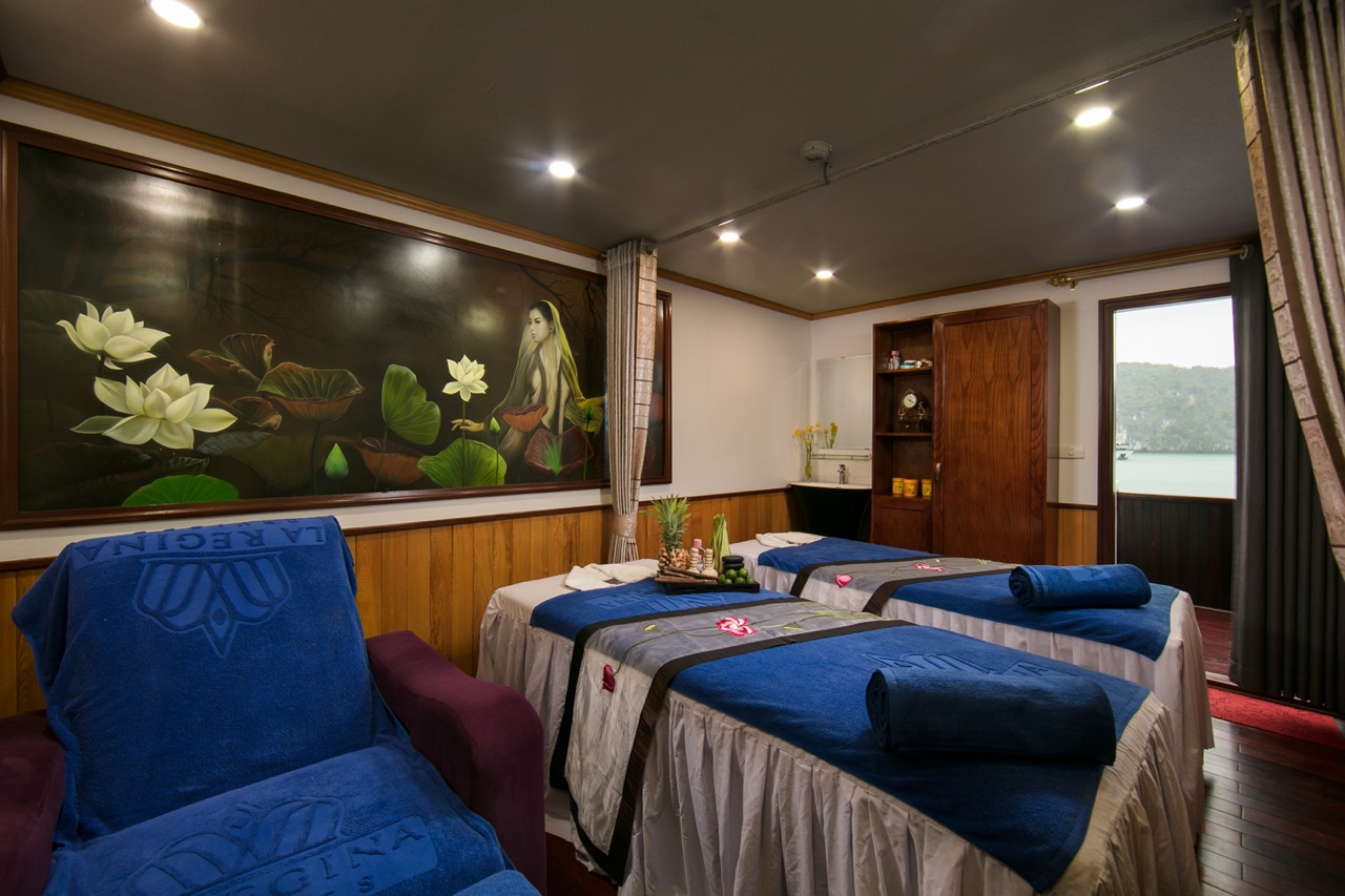 Spa room with massage beds and tranquil ambiance, overlooking scenic landscape through large window.