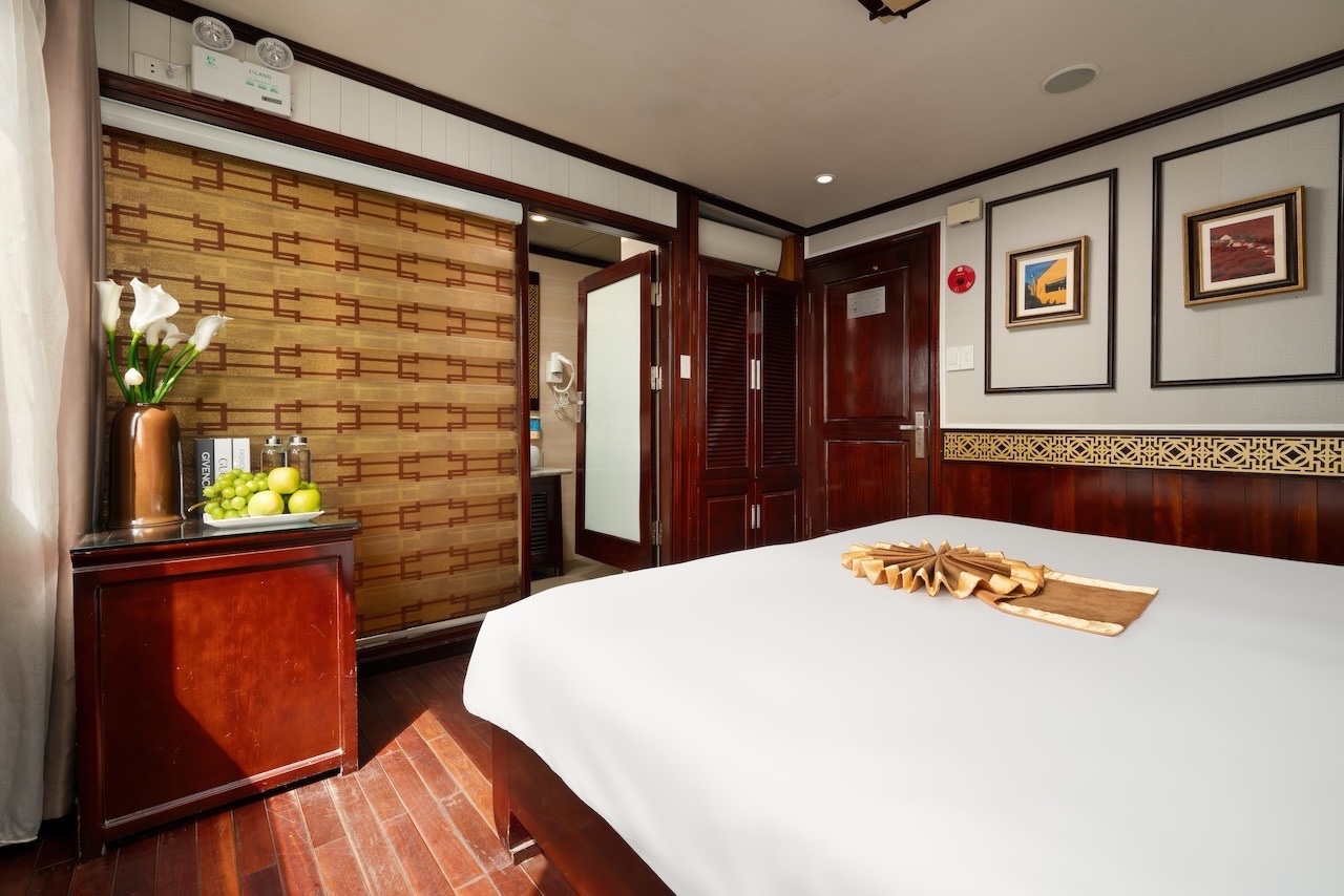 Relaxing cruise balcony view of Halong Bay with serene waters and limestone karsts.