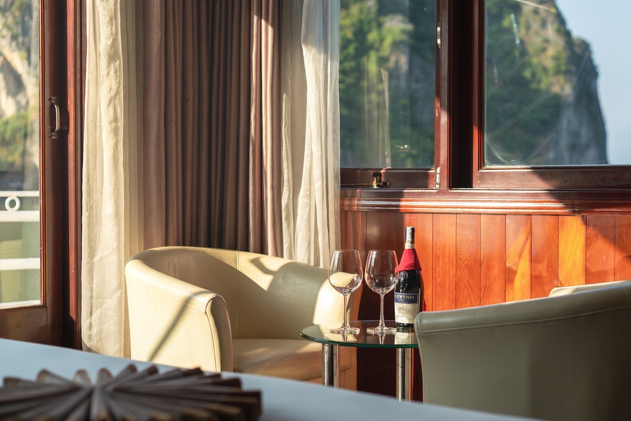 Scenic view of a cruise balcony in Halong Bay with elegant seating and sunset lighting, perfect for.