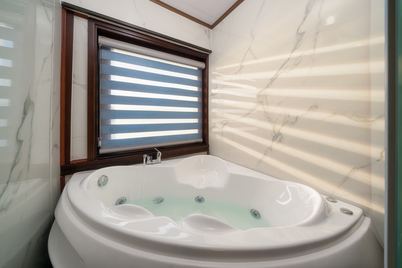 Relaxing cruise bathroom with modern amenities and scenic window view in Bai Tu Long Bay.