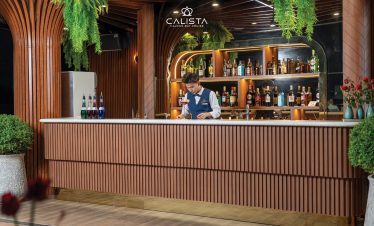 Elegant cruise bar scene with tropical greenery in Halong Bay.