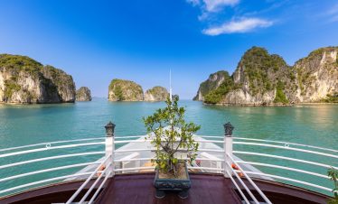 Stunning view from a cruise balcony in Halong Bay with turquoise waters and limestone islands, perfe.