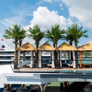 Luxurious yacht deck with tropical cabanas and swaying palm trees, perfect for a vacation in Vietnam.