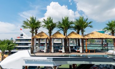 Luxurious yacht deck with tropical cabanas and swaying palm trees, perfect for a vacation in Vietnam.