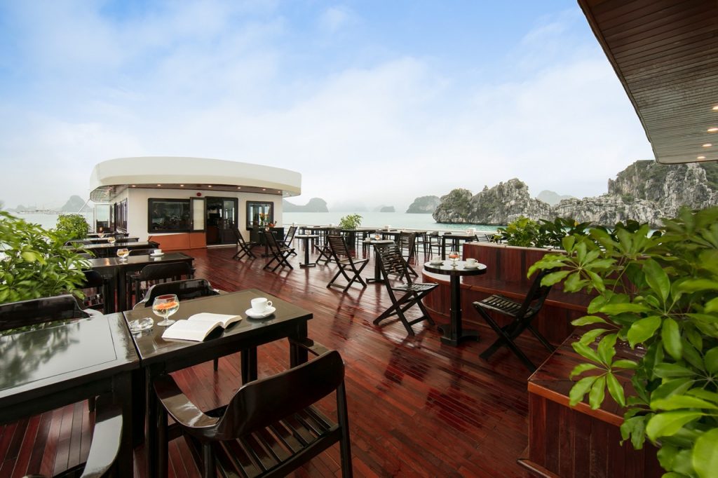 Stunning view from a luxury cruise balcony overlooking Halong Bay's emerald waters and limestone kar.