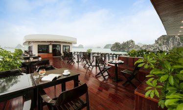 Stunning view from a luxury cruise balcony overlooking Halong Bay's emerald waters and limestone kar.