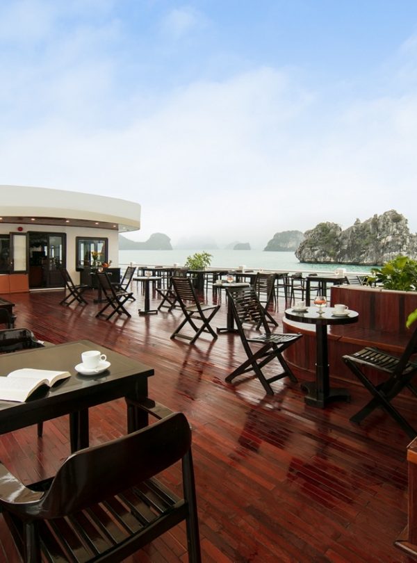 Stunning view from a luxury cruise balcony overlooking Halong Bay's emerald waters and limestone kar.
