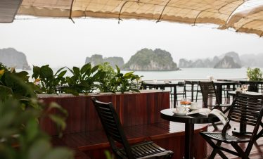 Aluminum balcony with seating overlooking Halong Bay's stunning limestone karsts, perfect for a rela.
