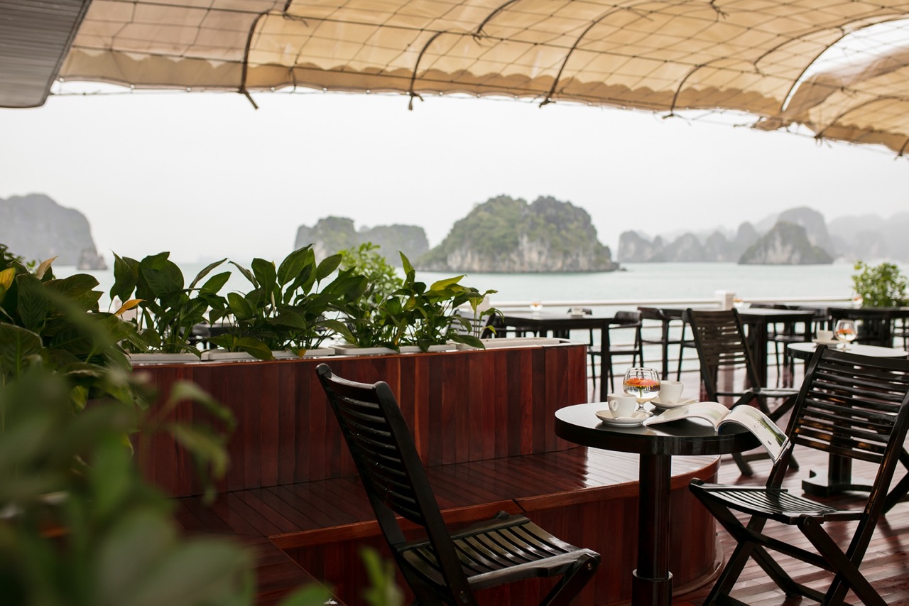 Aluminum balcony with seating overlooking Halong Bay's stunning limestone karsts, perfect for a rela.
