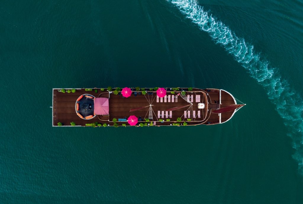 Luxury cruise boat in Halong Bay with deck and seating area - ViettrendTour.