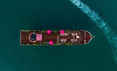 Luxury cruise boat in Halong Bay with deck and seating area - ViettrendTour.
