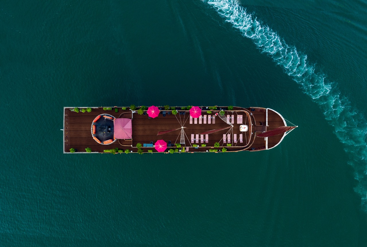 Luxury cruise boat in Halong Bay with deck and seating area - ViettrendTour.