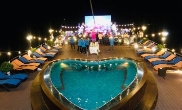 Luxury rooftop party with swimming pool and outdoor entertainment at night, Vietnam tourism.