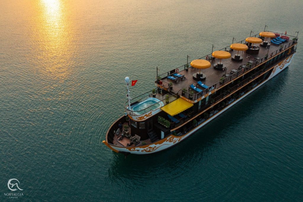 Stunning Halong Bay cruise ship with sun setting over calm waters, perfect for a memorable 2D1N voya.