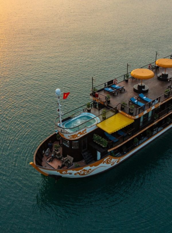 Stunning Halong Bay cruise ship with sun setting over calm waters, perfect for a memorable 2D1N voya.