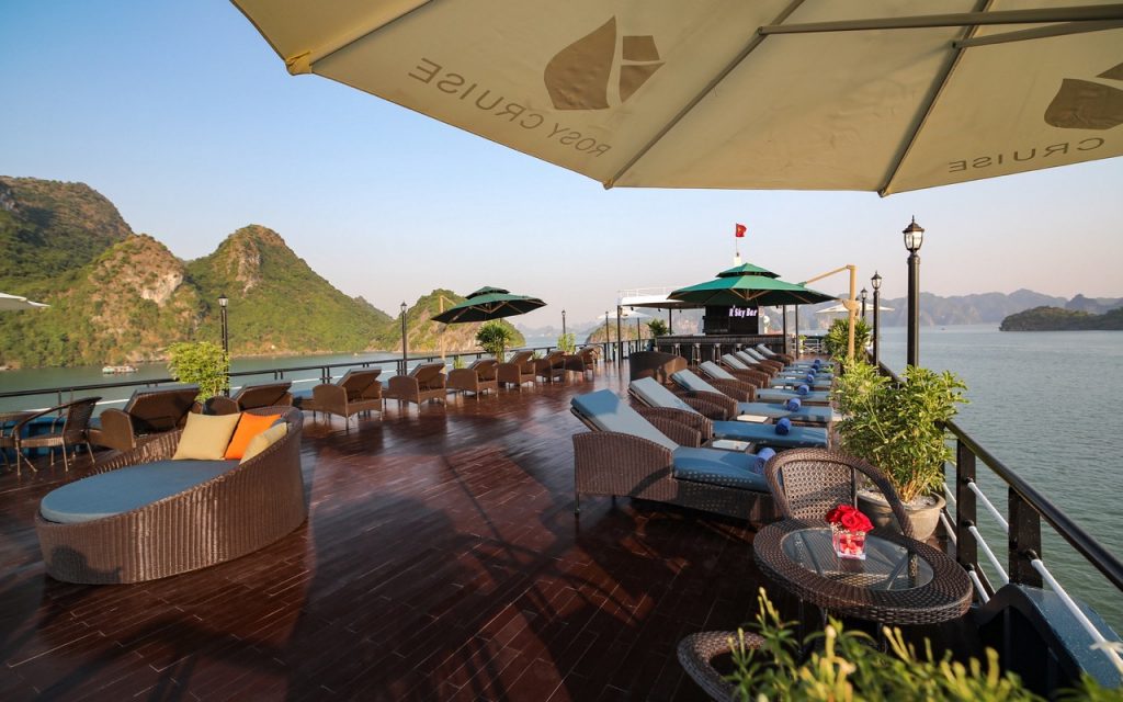 Stunning Halong Bay cruise balcony with panoramic views, relaxing lounge area, perfect for exploring.