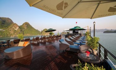 Stunning Halong Bay cruise balcony with panoramic views, relaxing lounge area, perfect for exploring.